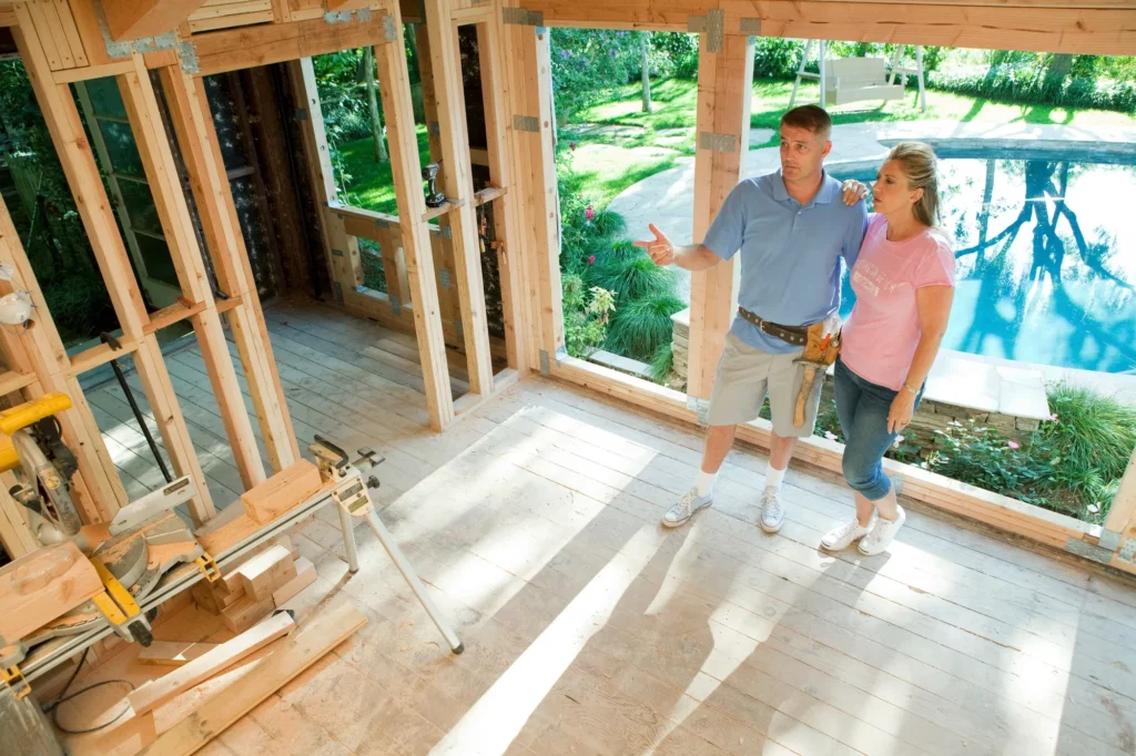 mature-couple-standing-in-construction-frame-of-home-extension